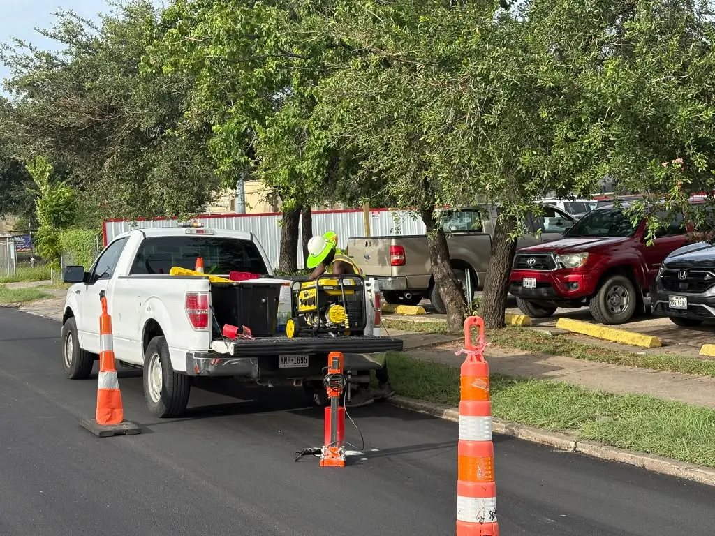 Work truck and coring rig set up with traffic cones on a parking lot