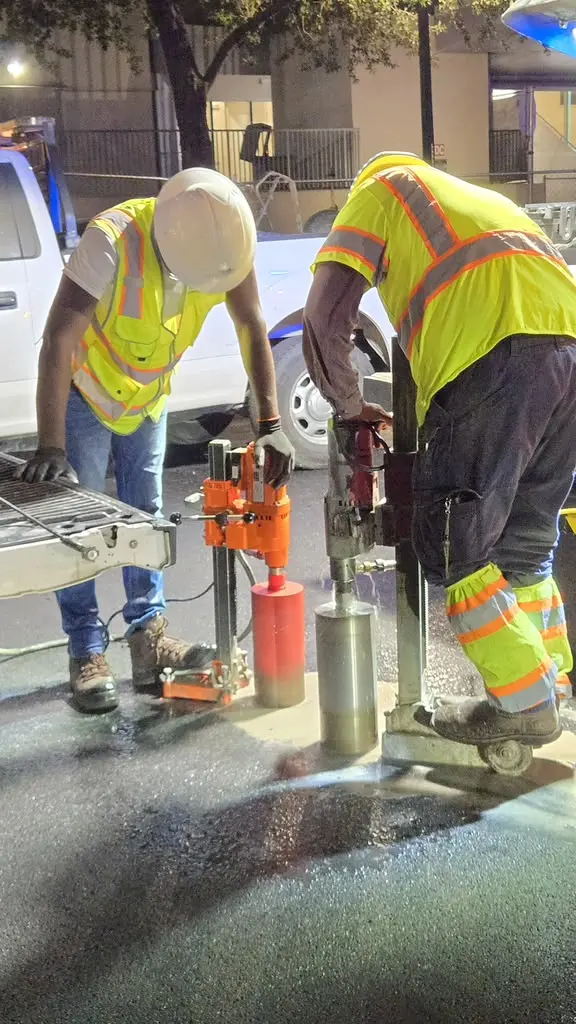 Close-up of core drills extracting pavement cores at night